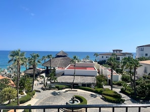 Un resort con piscina, palmeras y vistas al océano.