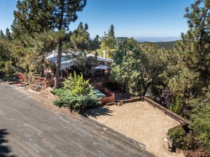 A house with a covered patio, surrounded by trees and a clear sky. - RidgeView | Hot Tub & Sauna | Wraparound Decks | Mountain Views | Idyllwild (Idyllwild)