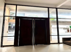 A modern hotel entrance with large glass doors, a tiled floor, and a view of the outside. - H room De Silom (Bangkok)