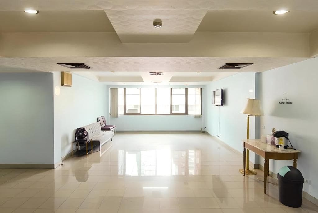 Una habitación amplia con sofá, mesa y lámpara.
