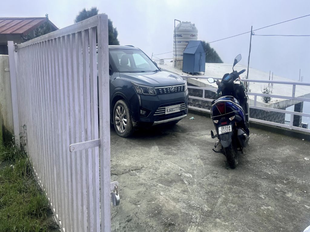 Un'area recintata con un SUV e una motocicletta parcheggiati.