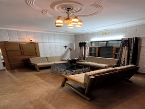 Una sala de estar con un conjunto de sofá, una mesa de centro y un aparador de madera.
