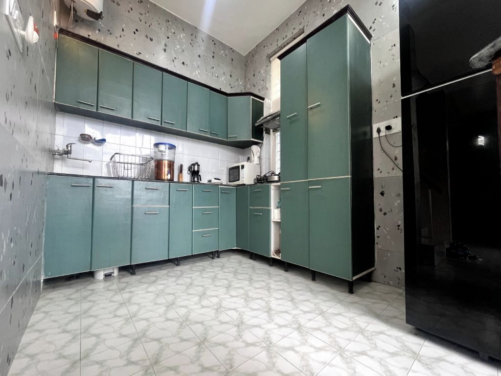Una cocina con armarios color aguamarina, un microondas y un refrigerador.