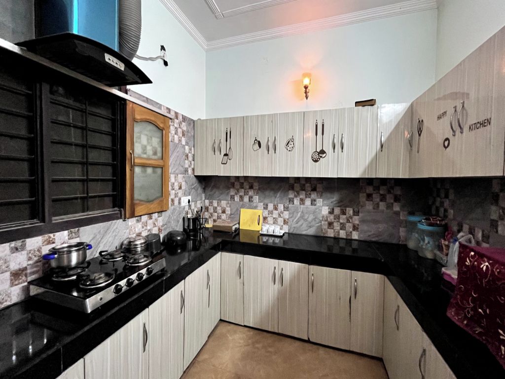A kitchen with a stove, cabinets, and a microwave.