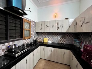 A kitchen with a stove, cabinets, and a microwave.