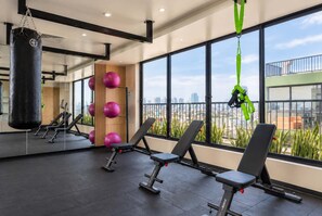 A gym with exercise equipment, large windows, and a punching bag. - Elegante 2BR con piscina y vistas (Miraflores)