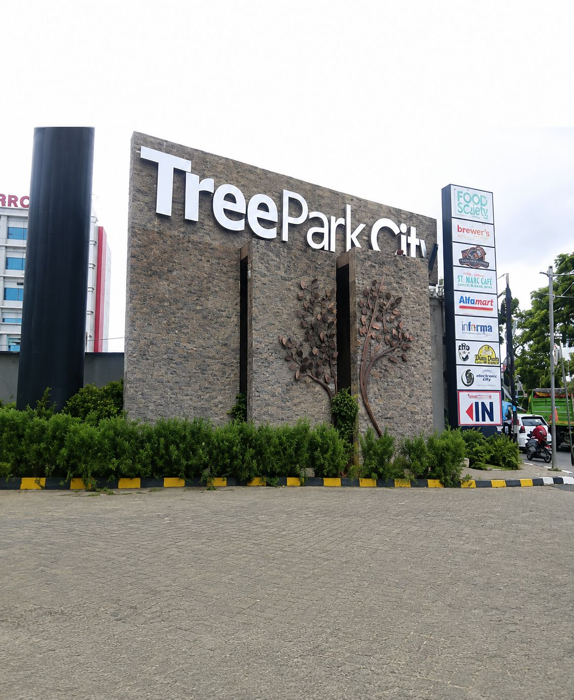 A building with a sign reading 'TreePark City' and a vertical sign with various business logos.