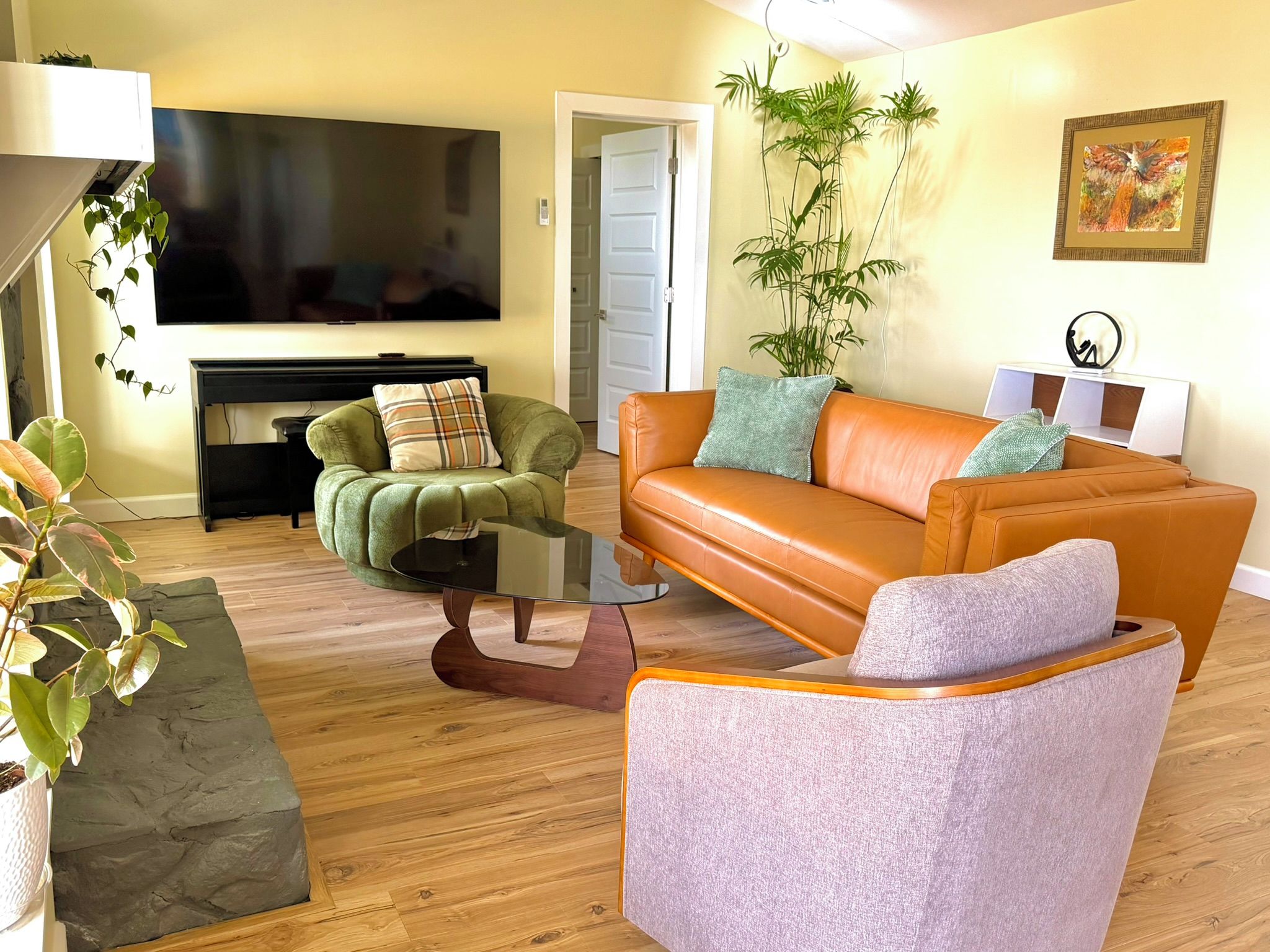 A living room with a sofa, armchair, and a television.
