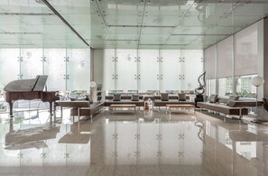 A spacious lobby with a grand piano, seating area, and large windows. - Blueground | Jingxin Village, pool, nr Taipei 101 (TPE-14) (Taipei)