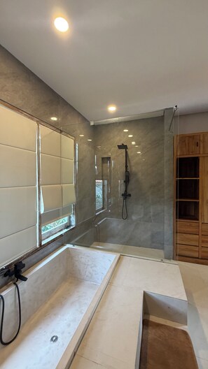 Un baño moderno con un espejo grande, una ducha y un armario de madera.