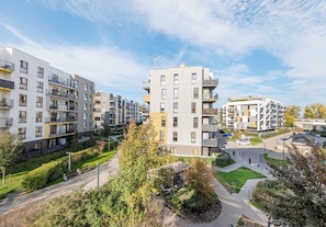 A residential building with multiple balconies, a central courtyard, and a surrounding green space. - Marywilska Spacious Apartment (Warszawa)