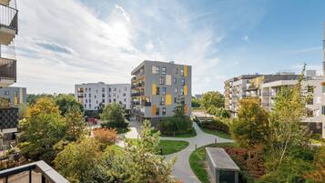 A residential building complex with multiple balconies, a central courtyard, and surrounding greenery.