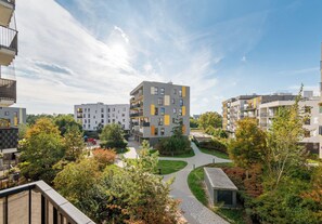 A residential building complex with multiple balconies, a central courtyard, and surrounding greenery. - Marywilska Spacious Apartment (Warszawa)