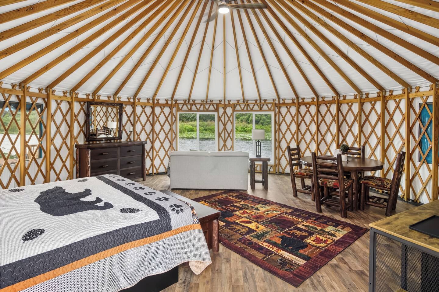 A yurt interior with a bed, a dining table, and chairs.