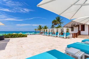 A resort with a pool area, lounge chairs, and a view of the ocean. - Airbnb Be Sky Top | 1BR with Private Rooftop (Bavaro)