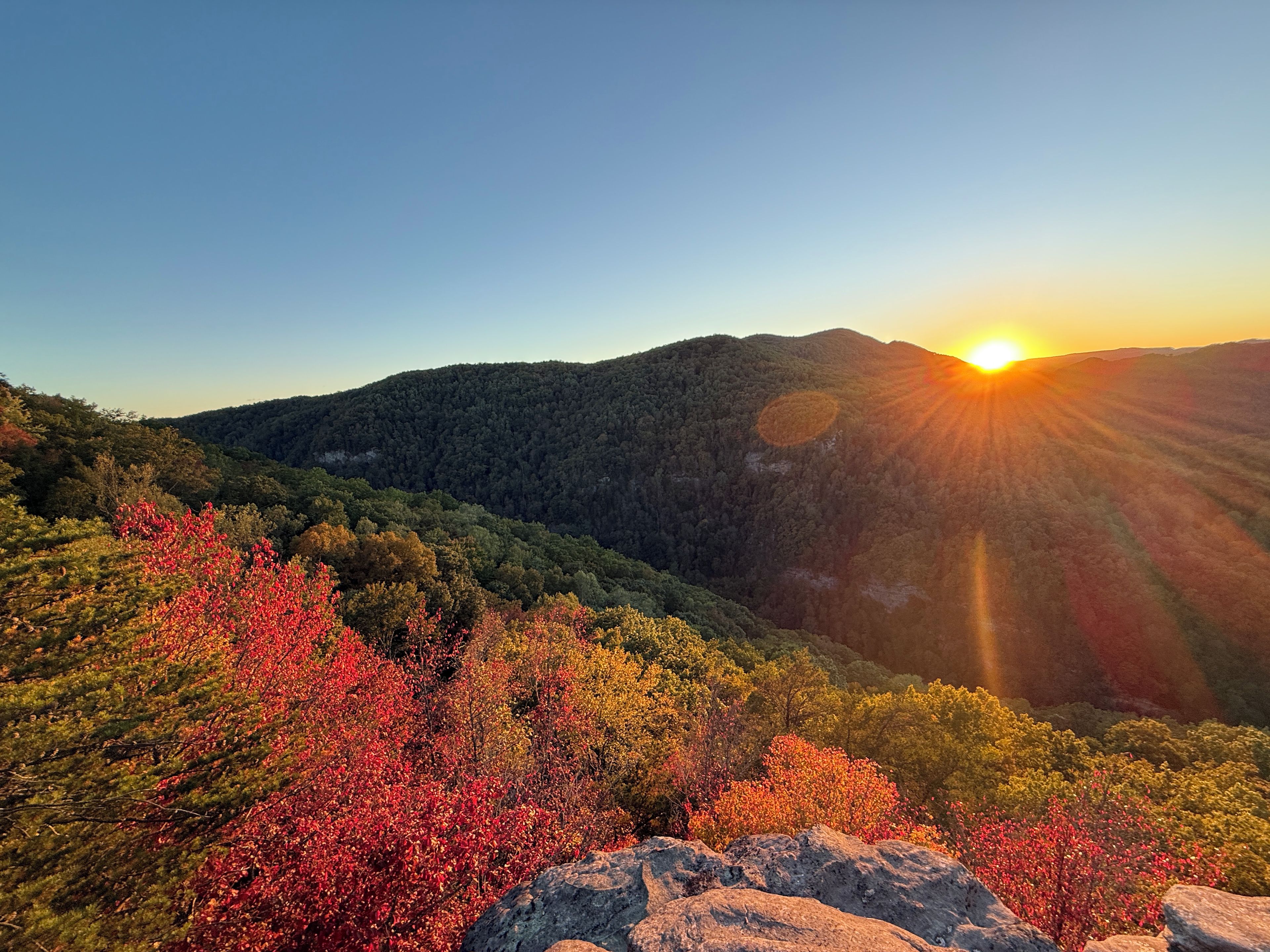 A mountainous landscape with a sunset.