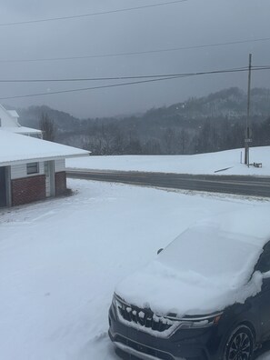 A snow-covered landscape with a road, a building, and a vehicle. - Cozy One-Bedroom Stay in the Appalachian Mountains (Haysi)