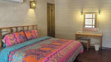 A bedroom with a bed, a desk, and a chair.
