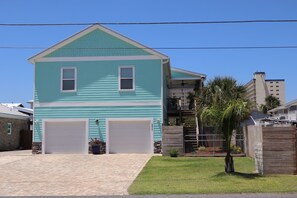 A two-story house with a garage, a small front yard, and a palm tree. - AlohaSunset: Affordable Beach Luxury & Walk to Beach (Panama City)