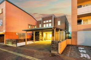 Un edificio moderno con entrada cubierta y fachada de ladrillo.
