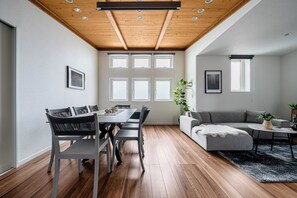 Un amplio espacio de sala con una mesa de comedor y sillas, un sofá y una mesa de centro.