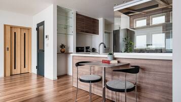 A modern kitchen with wooden cabinets, a built-in oven, and a window overlooking the room.