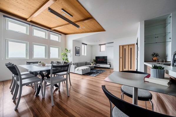 Un espacio habitable moderno con comedor, zona de estar y cocina.