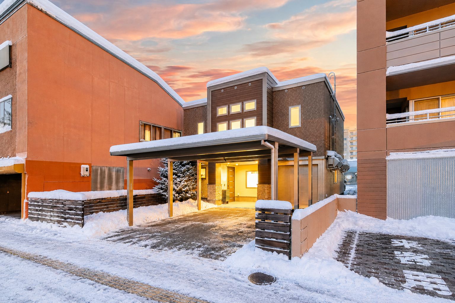 A multi-story building with a covered entrance and snow on the ground.
