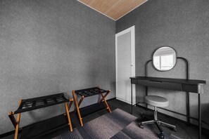 A room with a grey textured wall, a white door, a black desk with a round mirror, and a black chair with wooden legs. - Miipo (Sapporo)