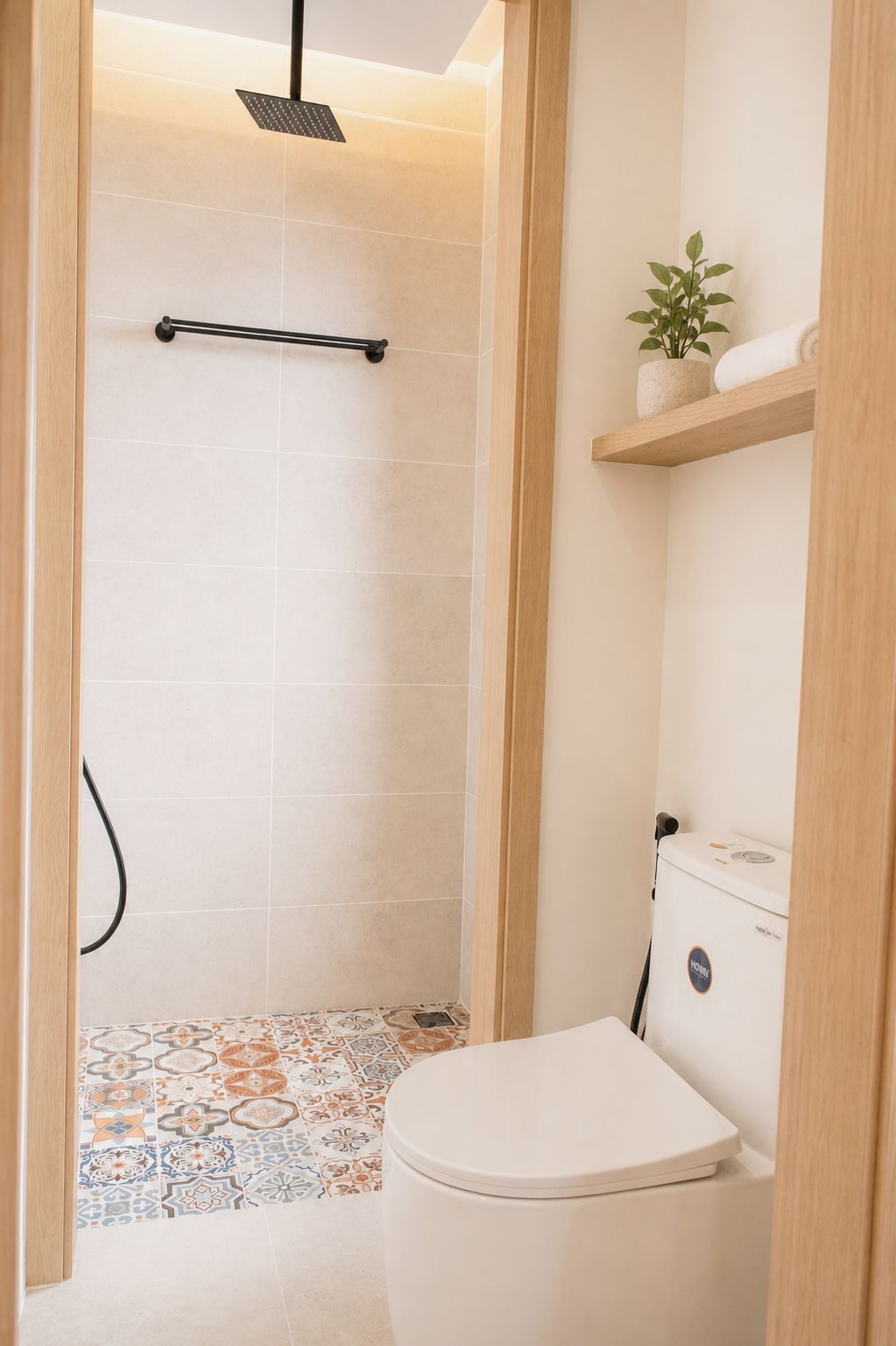 A bathroom with a shower, toilet, and a shelf with a plant.