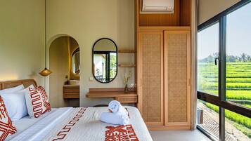 A bedroom with a large bed, a mirror, a wooden wardrobe, and a view of a green field.