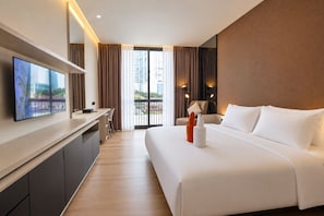 A hotel room with a bed, a desk, a TV, and a view of the city. - Muraku Mega Kuningan Jakarta (Jakarta)