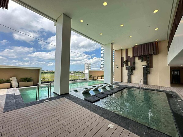 A rooftop pool area with a clear view of the sky and surrounding buildings.