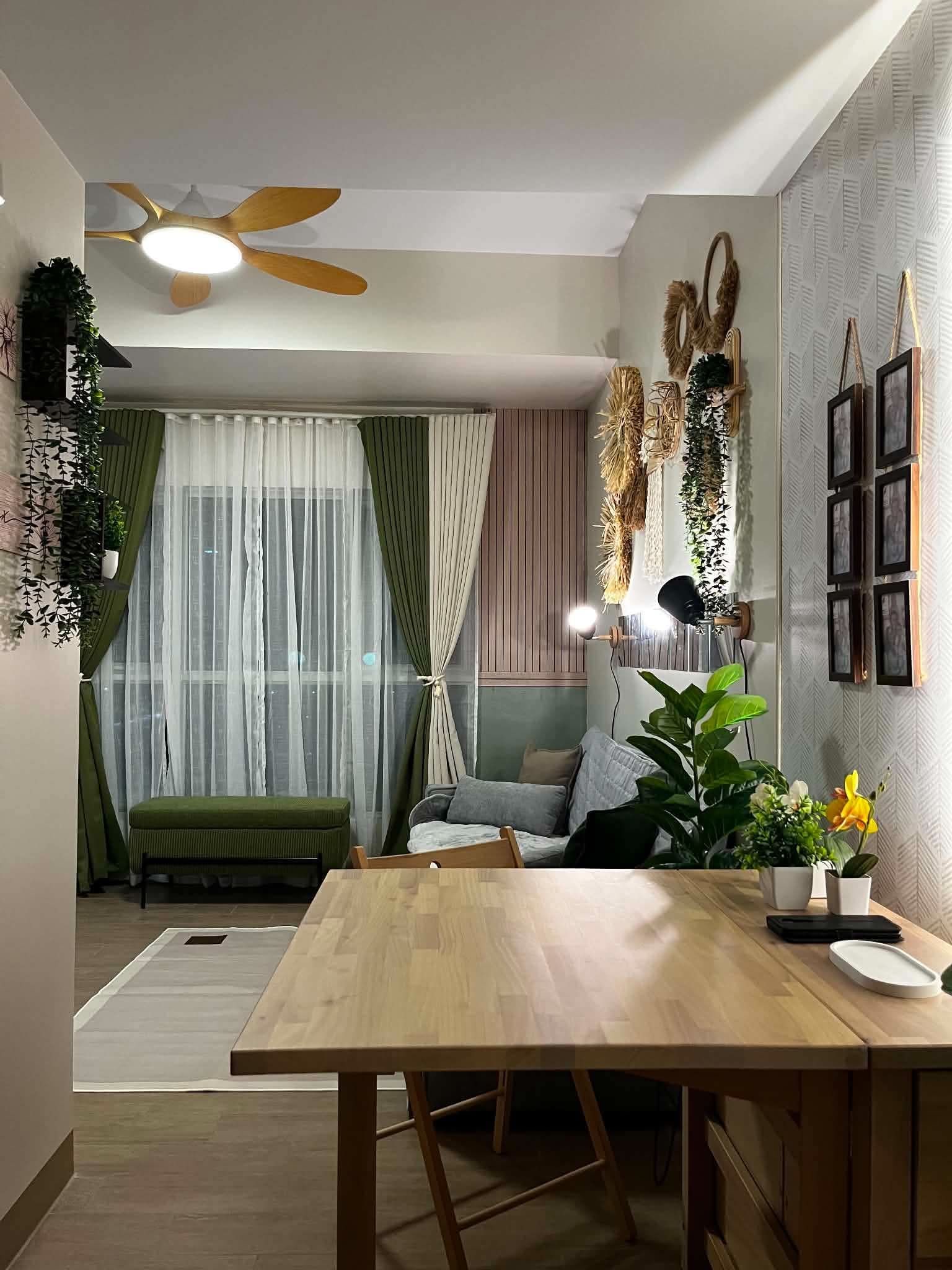 Een moderne woonkamer met een houten eettafel, een bank en een plafondventilator.