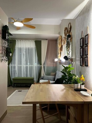 Een moderne woonkamer met een houten eettafel, een bank en een plafondventilator.