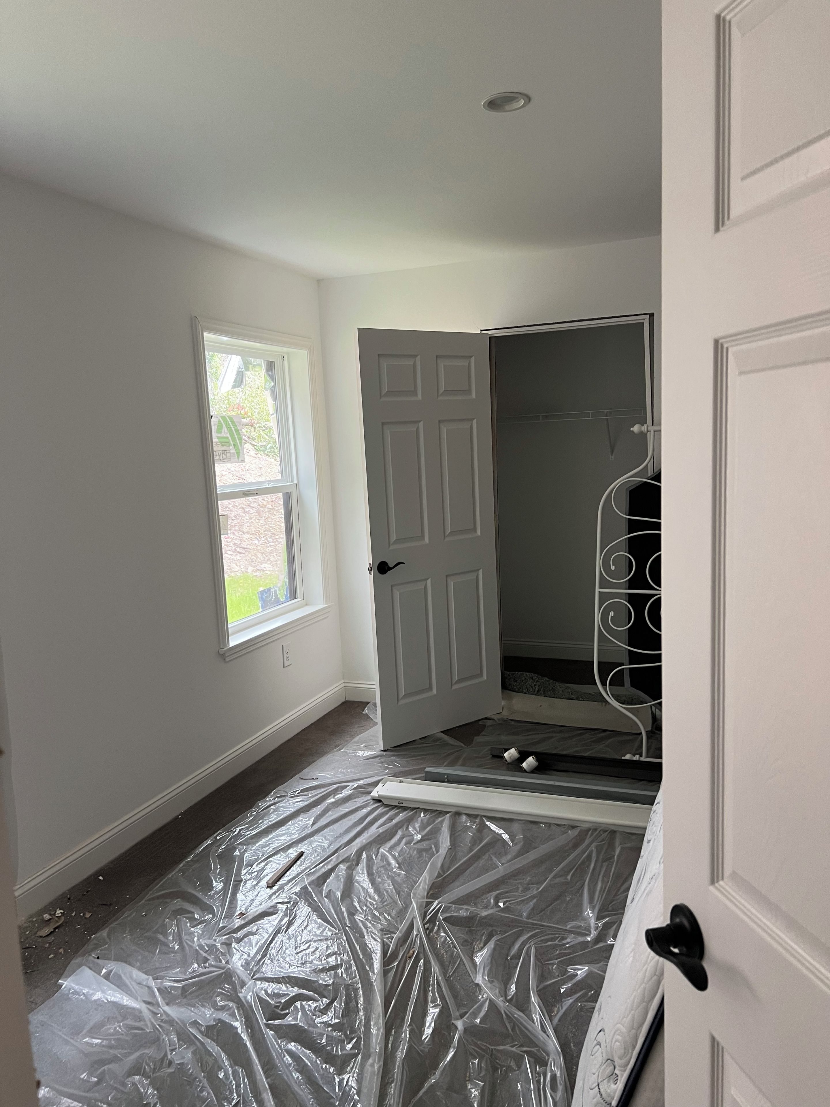 A room with a partially open door, a window, and a shower area.