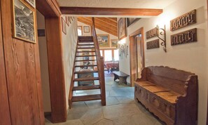 Eine Holztreppe führt zu einem Essbereich mit einer Bank und Wandhaken.