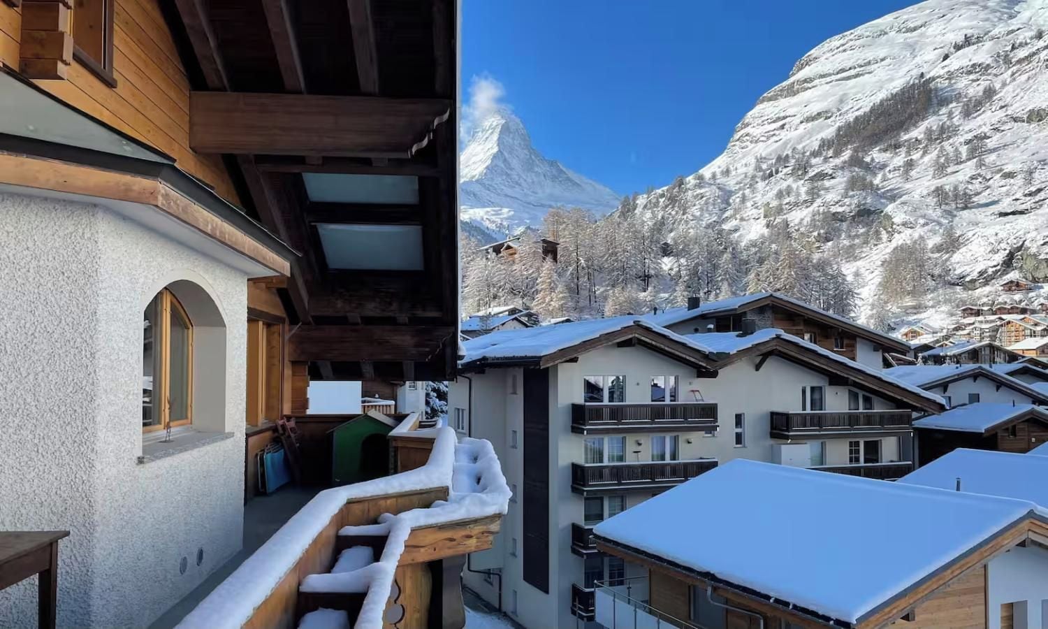 A snow-covered mountain village with wooden buildings and balconies.