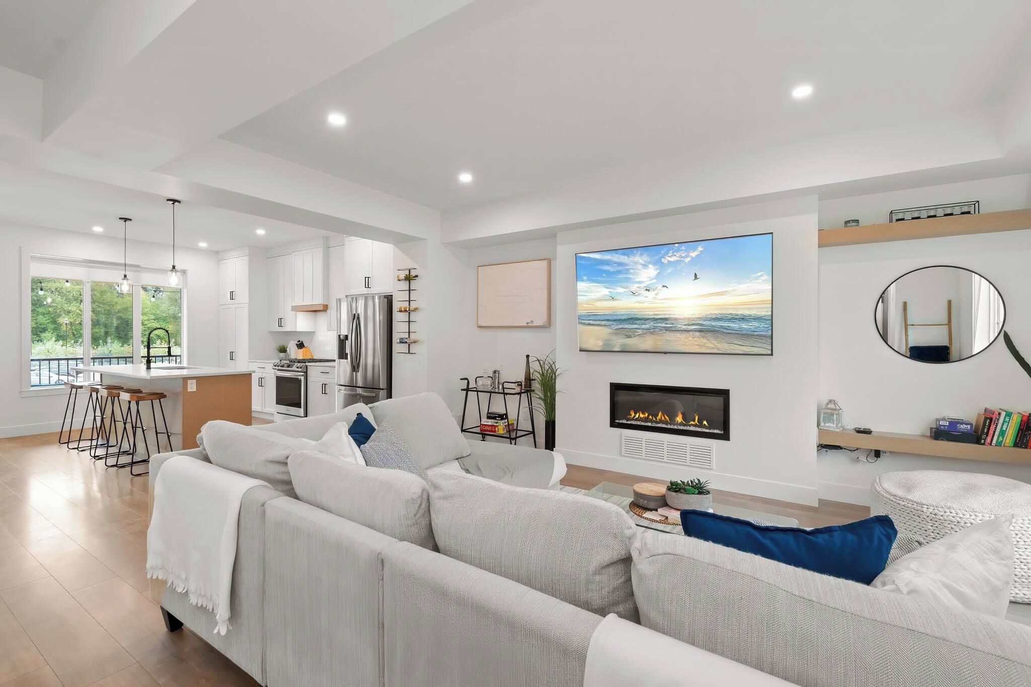 A modern living room with a large sofa, a fireplace, and a television.