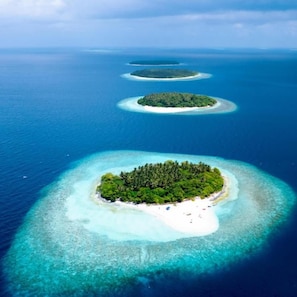 An aerial view of a series of islands with clear turquoise waters and white sandy beaches.