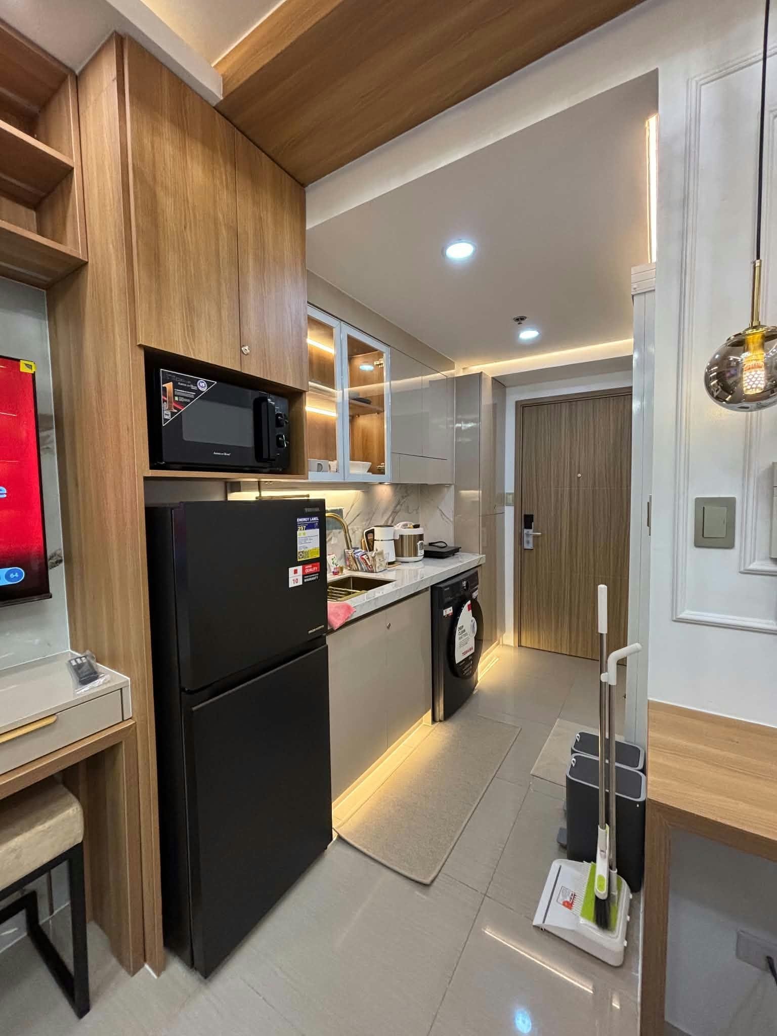 A modern kitchen with a refrigerator, microwave, and a sink.