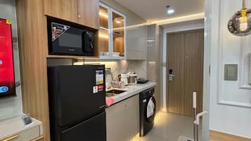 A modern kitchen with a refrigerator, microwave, and a sink.