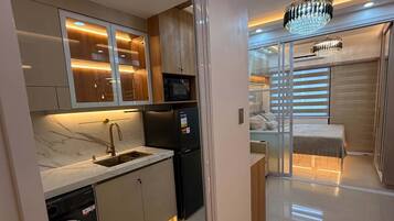 A modern kitchen with a built-in dishwasher, a refrigerator, and a microwave.
