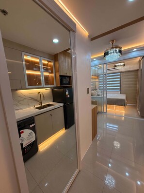 Una cocina moderna con lavavajillas, refrigerador y microondas.