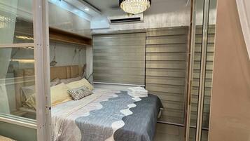 Un dormitorio con cama, candelabro y puerta corredera de vidrio.