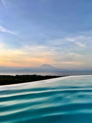 A panoramic view of a coastal landscape with a mountain in the distance. - PENIDA VIEW VILLAGE (Penida Island)
