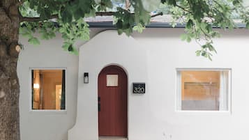 A house with a red door, a mailbox with the number 320, and two windows.