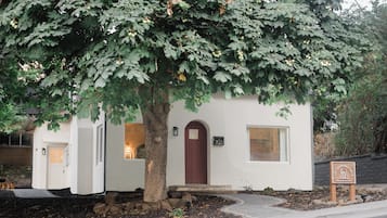 Un pequeño edificio de una sola planta con una puerta marrón oscuro, una ventana y un buzón.