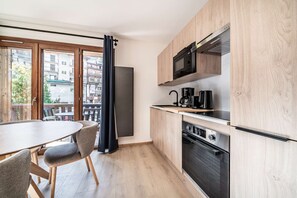 A modern kitchen with a built-in microwave, coffee maker, and oven. - JANIN 5 Charming renovated apartment 1 bedroom + cabin (MORZINE)