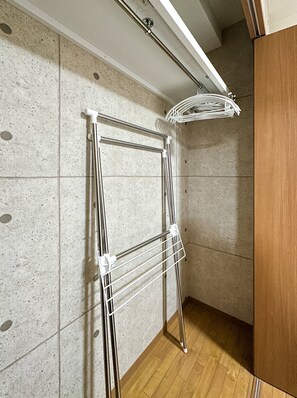 A corner of a room with a metal drying rack against a speckled wall and wooden flooring. - HANASTAY UJUN TSUTENKAKU (Osaka)